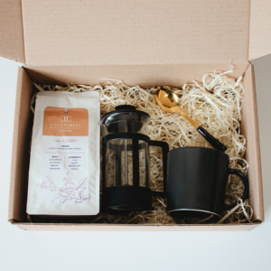coffee grounds coffee plunger coffee mug and coffee spoon presented in a gift box