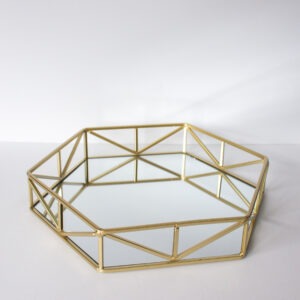 A gold tray with a mirror inside of it on a white table.